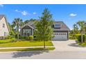 Inviting two-story gray home with well-maintained lawn, mature landscaping, and a convenient two-car garage at 1439 Rivers Cotton Rd, Charleston, SC 29412