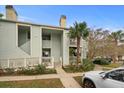 Attractive condo building with light green siding, white trim, a tropical palm tree, and well-maintained landscaping at 1481 Center Street Extension # 1102, Mount Pleasant, SC 29464