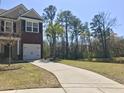 Charming two-story home with a brick accent, white garage door, landscaped front yard, and long driveway at 1720 Restoration Ct, Charleston, SC 29414