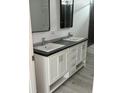 Modern bathroom featuring a double vanity with chrome faucets and dark countertops at 18441 Round O Rd, Round O, SC 29474