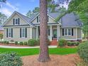 Traditional one-story home with a welcoming front porch and tidy landscaping features at 195 Prestwick Ct, Summerville, SC 29483