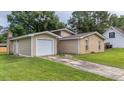 View of the house with attached garage, driveway, and manicured lawn at 212 Kentucky Dr, Ladson, SC 29456