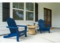 Inviting front porch with comfortable blue Adirondack chairs, perfect for relaxing and enjoying the outdoors at 217 7Th Ave, Mount Pleasant, SC 29464