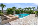 Relaxing backyard pool with spa, surrounded by lush greenery and palm trees on a brick patio at 2219 Kemmerlin St, Johns Island, SC 29455