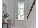 Bright foyer with a white door and a tasteful round mirror decorates the entrance at 2241 Dewees Creek Dr, Mount Pleasant, SC 29466