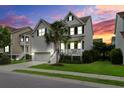 Beautiful exterior view of a home with a charming front porch, manicured lawn, and twilight sky at 2241 Dewees Creek Dr, Mount Pleasant, SC 29466