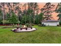 Serene backyard with fire pit, bench seating, and detached garage at 242 Cheyenne Rd, Summerville, SC 29483