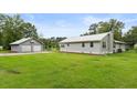 A home with a metal roof, green lawn, and a detached garage at 245 Lake Dr, Summerville, SC 29483