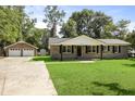 Classic brick home with detached garage featuring a green lawn and traditional design elements at 267 Industrial Rd, Walterboro, SC 29488