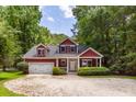 Charming two-story red home featuring a well-manicured lawn and an attached garage at 2941 Murraywood Rd, Johns Island, SC 29455