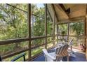 Relaxing screened-in porch with comfortable white Adirondack chairs and serene views of the lush green foliage at 3577 Shipwatch Rd, Kiawah Island, SC 29455
