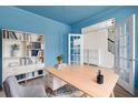 Charming office space with light wood desk, white shelves, blue accent walls, and view to stairway at 5133 Park Creek Ave, North Charleston, SC 29418