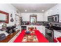 Bright kitchen featuring white cabinets, stainless steel appliances, and a dining area at 5209 Sterrett St, North Charleston, SC 29405