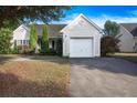 Single-story home featuring an attached garage, manicured lawn, and quaint landscaping at 5217 Copley Cir, Summerville, SC 29485