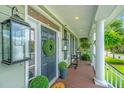 Charming front door with decorative wreath and lantern, leading to a cozy porch and stylish home entrance at 544 Two Mile Run, Johns Island, SC 29455
