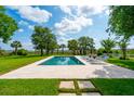 Relaxing pool area with travertine tile, chaise lounges and lush greenery provides a private outdoor oasis at 591 Island Walk East, Mount Pleasant, SC 29464