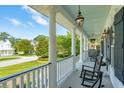 Spacious front porch with rocking chairs, offering a relaxing outdoor space with neighborhood views at 591 Island Walk East, Mount Pleasant, SC 29464
