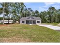 A full view of the house including the wide open green front yard and a long driveway to the side at 6513 Highway 162, Hollywood, SC 29449
