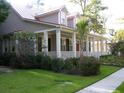 Charming two-story home with a welcoming front porch, red roof, and lush green lawn at 7021 Schooner St, Charleston, SC 29492