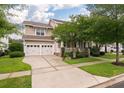 Beautiful home with a two-car garage, well-manicured lawn, and covered front porch framed by mature trees at 705 Quintan St, Summerville, SC 29486
