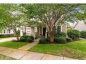 Inviting home exterior featuring a well-maintained front yard, walkway, and covered porch framed by trees at 705 Quintan St, Summerville, SC 29486