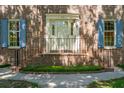 Brick home's front entrance with blue shutters, a small porch and a well manicured landscaped yard at 712 Wakendaw Blvd, Mount Pleasant, SC 29464