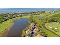 Beautiful aerial view of a lakeside home, surrounded by lush greenery, golf course, and ocean backdrop at 930 Sealoft Villa Dr, Seabrook Island, SC 29455