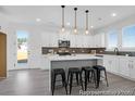 Modern kitchen with white cabinets, stainless steel appliances, a gray backsplash, and a spacious island with seating at 1023 Marsh Harrier Dr # Cc3-3-5P, Ravenel, SC 29470