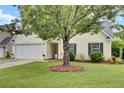 Beautiful home with a manicured lawn, inviting curb appeal, and a two-car garage at 104 Lancaster Ct, Goose Creek, SC 29445