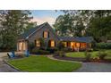 Charming home with a cozy fire pit area, manicured landscaping, and warm lighting that enhance its inviting curb appeal at 110 W 2Nd South St, Summerville, SC 29483