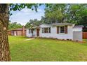 Quaint white brick home with lush lawn, mature trees, and a cozy, inviting atmosphere at 111 Circle Dr, Summerville, SC 29485