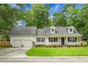 Charming one-story home featuring a well-manicured lawn, two-car garage, and a welcoming front porch at 114 Heritage St, Summerville, SC 29485