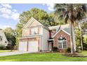 Two-story home with brick accents, red shutters, palm tree, and a lush green lawn at 126 Thousand Oaks Cir, Goose Creek, SC 29445