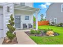 Cozy front porch with seating, decorative landscaping, and a charming entrance to the home at 146 Chaste Tree Cir, Goose Creek, SC 29445
