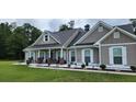 Inviting covered front porch with stone pillars and decorative accents, enhancing curb appeal at 148 Hidden Hills Rd, Cross, SC 29436