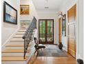 Elegant foyer with hardwood floors, staircase with iron railings, and natural light flooding through glass doors at 1612 John Fenwick Ln, Johns Island, SC 29455