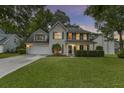 Inviting two-story home with green lawn and manicured shrubbery beneath front windows at 1616 Dotterers Run, Charleston, SC 29414