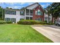 Inviting two-story condo with a brick facade, screened porch, lush lawn, and a private driveway at 163 Golfview Ln, Summerville, SC 29485