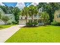 Charming two-story home with double porches, a well-manicured lawn, and palm trees at 1721 Wellstead St, Mount Pleasant, SC 29466