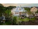 Beautiful elevated home featuring mature trees, an outdoor patio, and a metal roof at 1809 Rushland Grove Ln, Johns Island, SC 29455