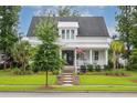 Charming two-story home featuring a well-manicured lawn, lush landscaping, and inviting front porch at 1903 Bolden Dr, Mount Pleasant, SC 29466