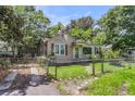 Charming single-story home with a grassy front yard, chain link fence, and mature trees providing ample shade at 2665 Ranger Dr, North Charleston, SC 29405