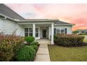 Cozy covered front porch with decorative columns and immaculate landscaping provides a welcoming entrance at 361 Waterlily Way, Summerville, SC 29486