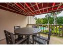Cozy outdoor patio with a table and chairs overlooking the community pool area and greenery at 408 Yacht Harbor Ct # Share 2, Isle of Palms, SC 29451