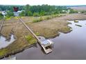 Aerial view of waterfront property featuring a private dock with a gazebo and marsh views at 4385 Ten Shillings Way, Ravenel, SC 29470