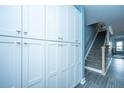 Hallway featuring a built-in white storage cabinet and a staircase with gray carpet and wood trim at 4991 Lake Palmetto Ln, North Charleston, SC 29418