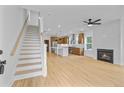 Spacious living room featuring wood flooring, a staircase, a modern fireplace and view into a kitchen with an island at 501 Joseph St, Charleston, SC 29412