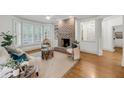 Inviting living room showcasing a brick fireplace, wood floors, and neutral decor at 701 Hibbens Grant Blvd, Mount Pleasant, SC 29464