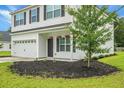 Close up of home's entrance features a well manicured lawn, mulch bed, and hanging plants at 717 Butter Rd, Bonneau, SC 29431
