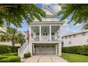 Inviting front of a two-story home showcasing a charming porch with hanging swings, a two-car garage and brick driveway at 732 Gate Post Dr, Mount Pleasant, SC 29464